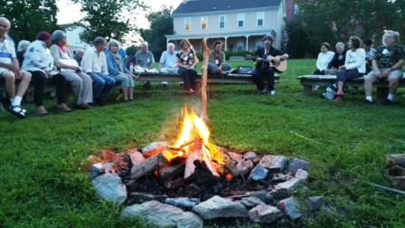 Campfire at the reunion featuring a guitar player and Somemores